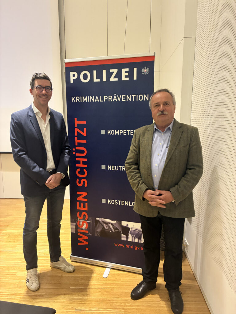 Chefinspektor Janisch und Wiener Kammerpräsident Saiko vor dem Polizei Logo.