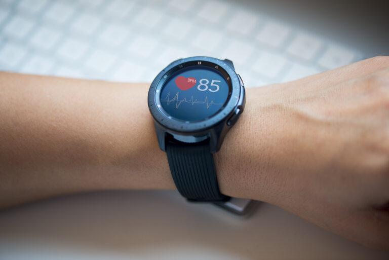 Symbolbild: Eine Smartwatch misst den Puls an einer Hand.