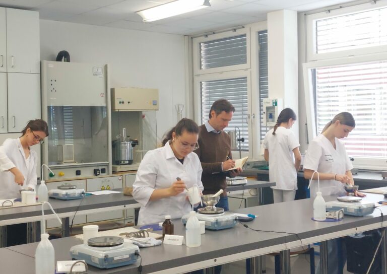 PKA-Lerhlinge bei der Salbenherstellung, dazwischen Juror Feldmann.