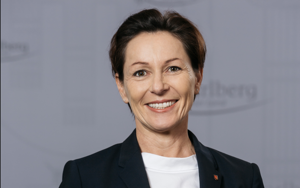 Martina Rüscher hat kurze dunkle Haare und trägt einen schwarzen Blazer und ein weißes T-shirt