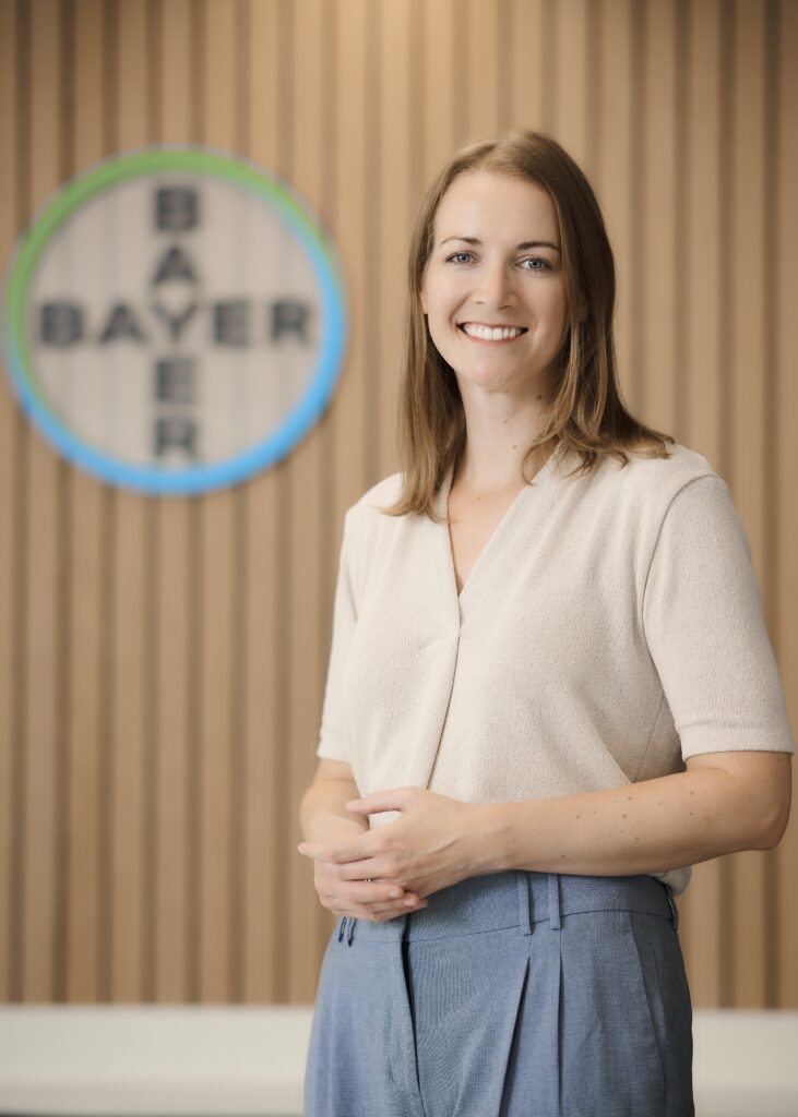 Helga Aigner ist Mitte Dreißig, trägt schulterlange braune Haare und lächelt.