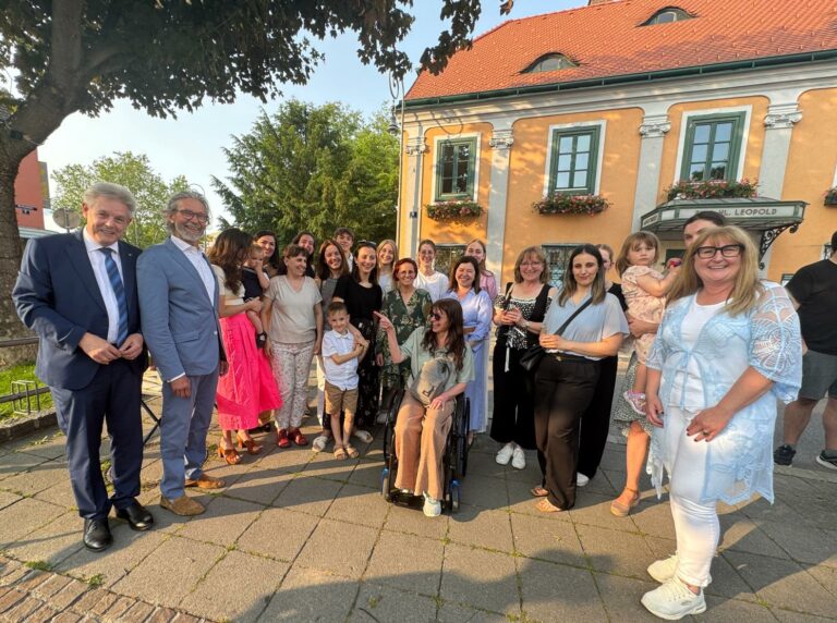 Der Konzessionär Linsmayer feiert it zahlreichen Freunden und Unterstützern. Sie stehen im Halbkreis vor der Apotheke.