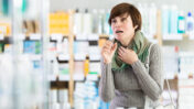 Hustende Frau in der Apotheke