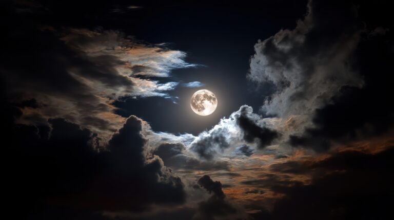 Symbolbild: Ein Vollmond tritt aus den Wolken hervor und strahlt hell.