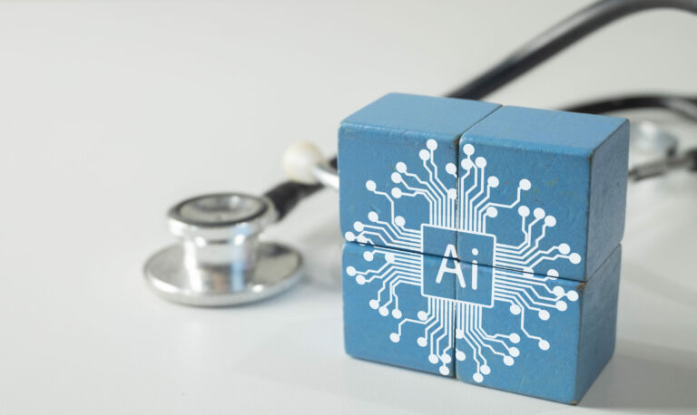 Symbolbild: Vier blaue Bauklötze auf deinen LEiterplattensymbole die KI andeuten sollen. Daneben liegt ein Stethoskop.