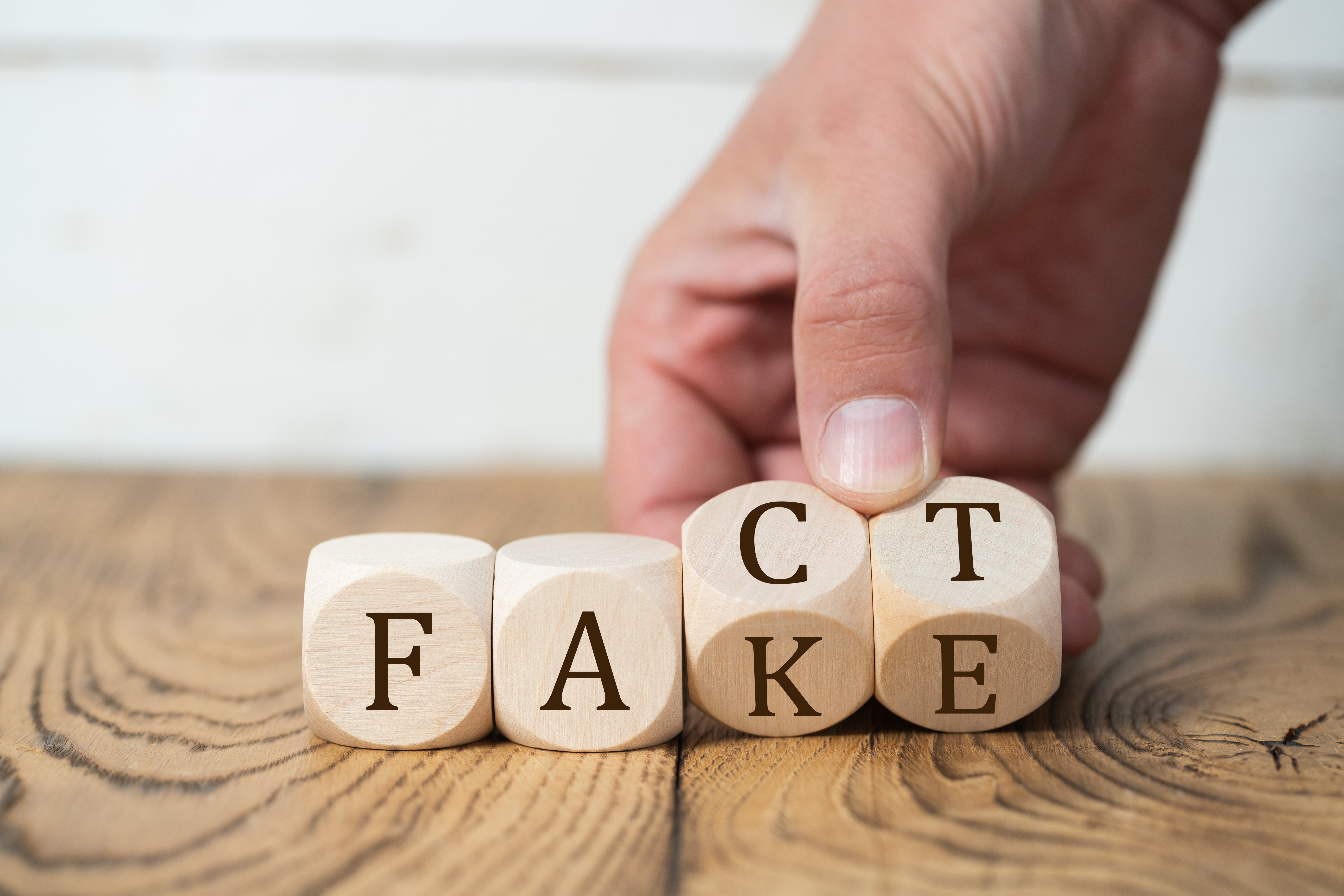 Symbolbild: Würfel die umgedreht werden von "FACT" zu "FAKE".