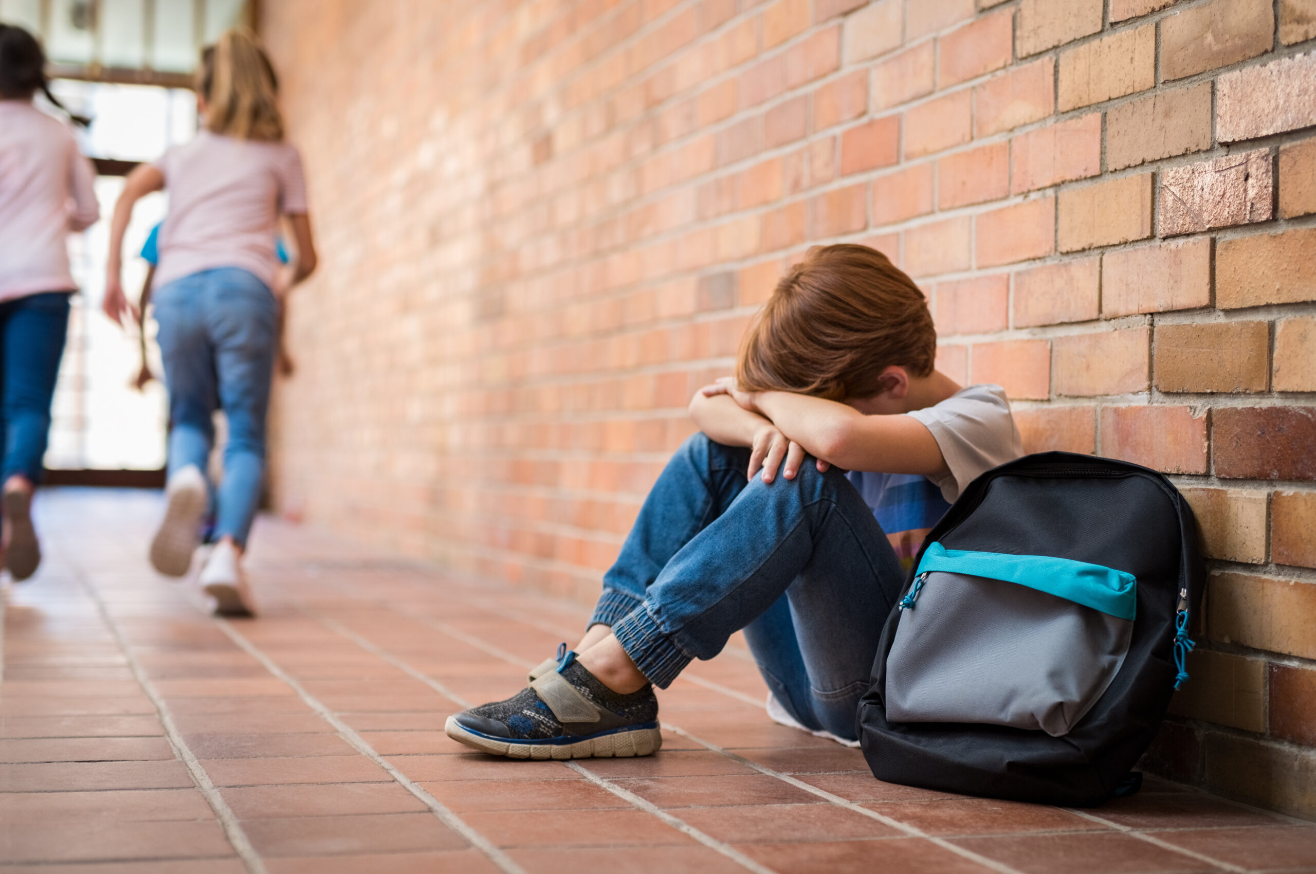 Schulkind traurig auf dem Boden