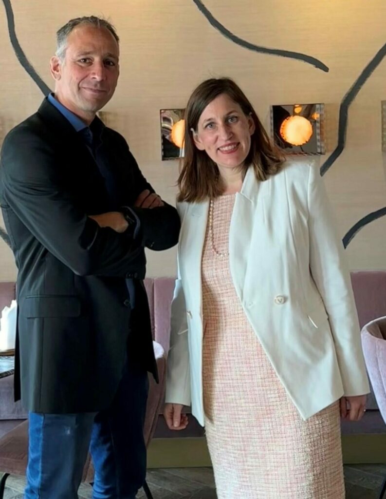 Karma Hohl und Thomas Schmit bei ihrem Event. Sie stehen nebeneinander und lächeln.