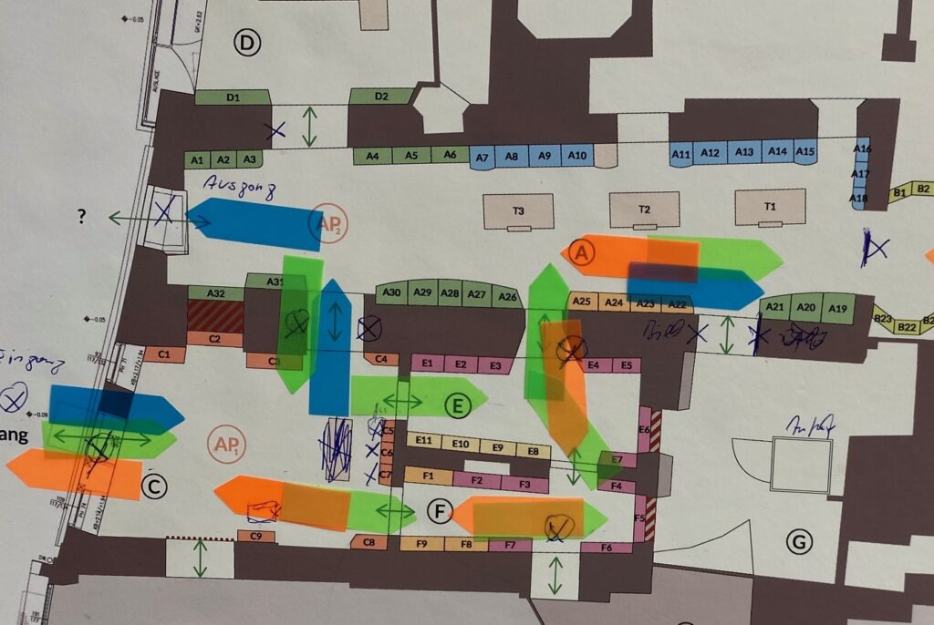 Ein Apotheken-Grundriss ist abgebildet. Verschiedene Post-Its und Markierungen weisen auf die Planung hin.