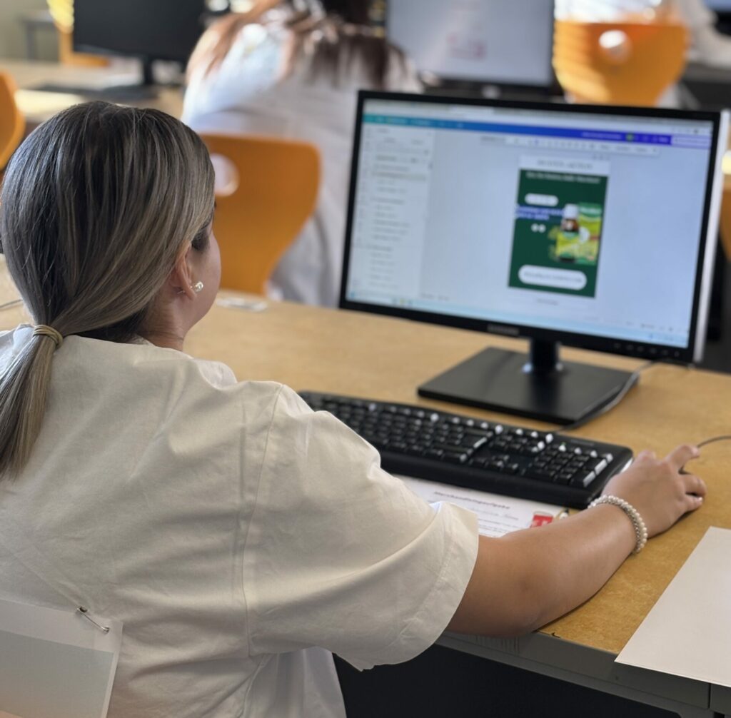 Eine Teilnehmerin sitzt am PC und arbeitet an einem Social Media Posting.