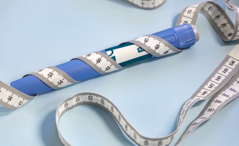 Symbolbild: Abnehmspritze mit einem Maßband umwickelt.