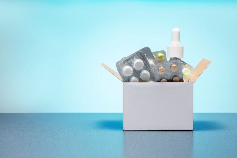 Symbolbild: Eine Kartonbox mit verschiedenen Medikamentenblistern und einem Nasenspray.