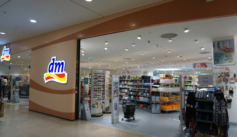 Symolbild: Ein dm store von außen. Man sieht die Regale mit den Produkten.