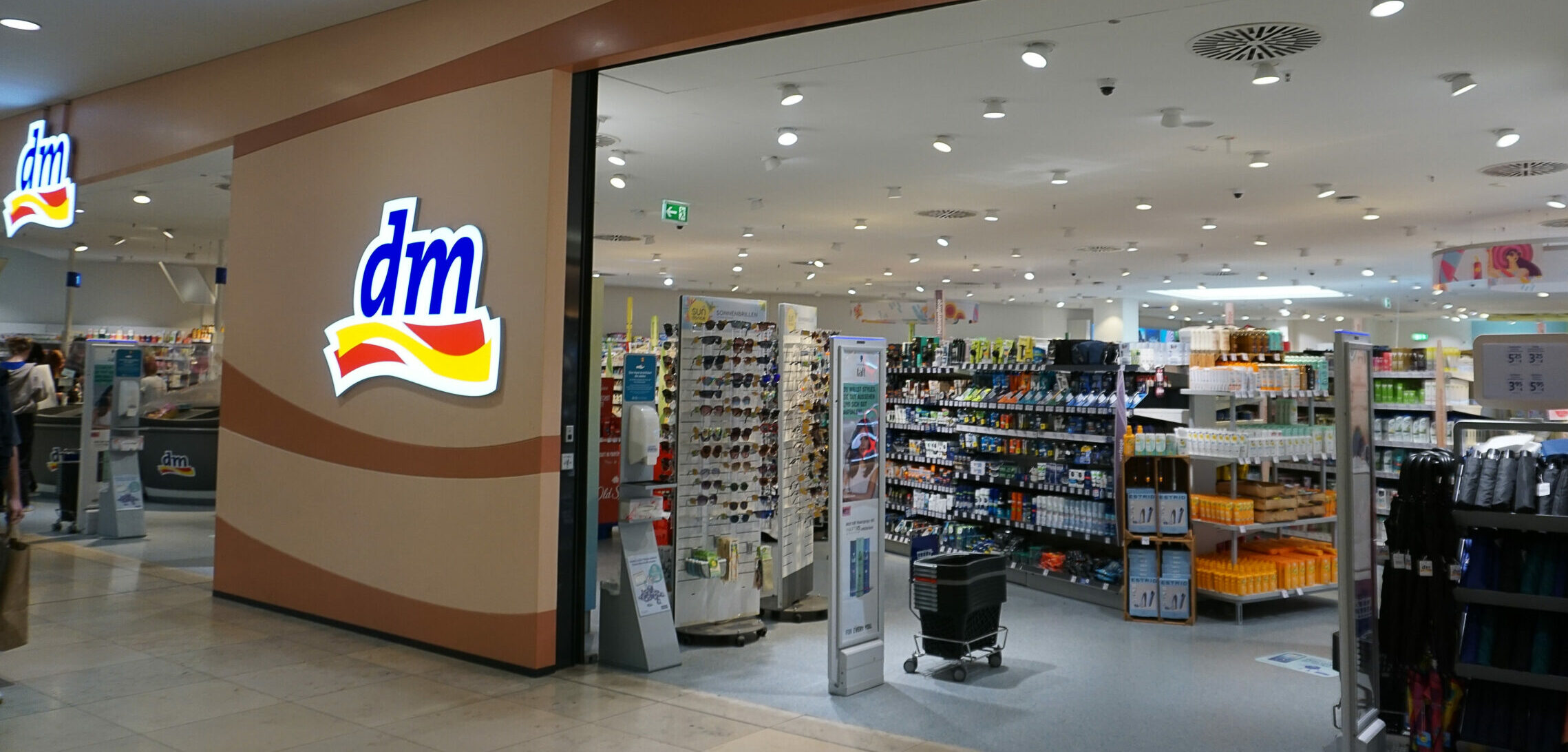 Symolbild: Ein dm store von außen. Man sieht die Regale mit den Produkten.