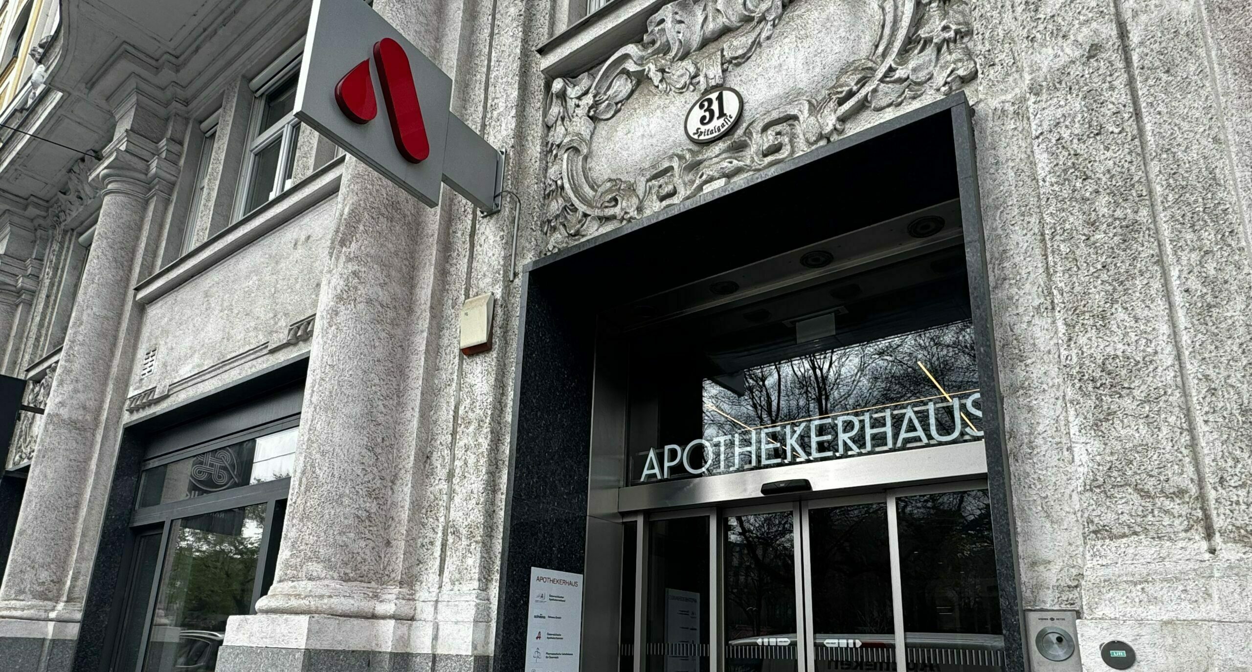 Das Apothekerhaus in Wien. Eine graue Fassade wird von einem roten A geziert.