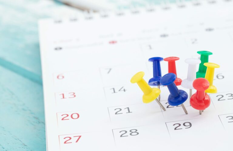 Symbolbild: In einem Kalender stecken viele bunte Reiszwecken am 22.ten des Monats.