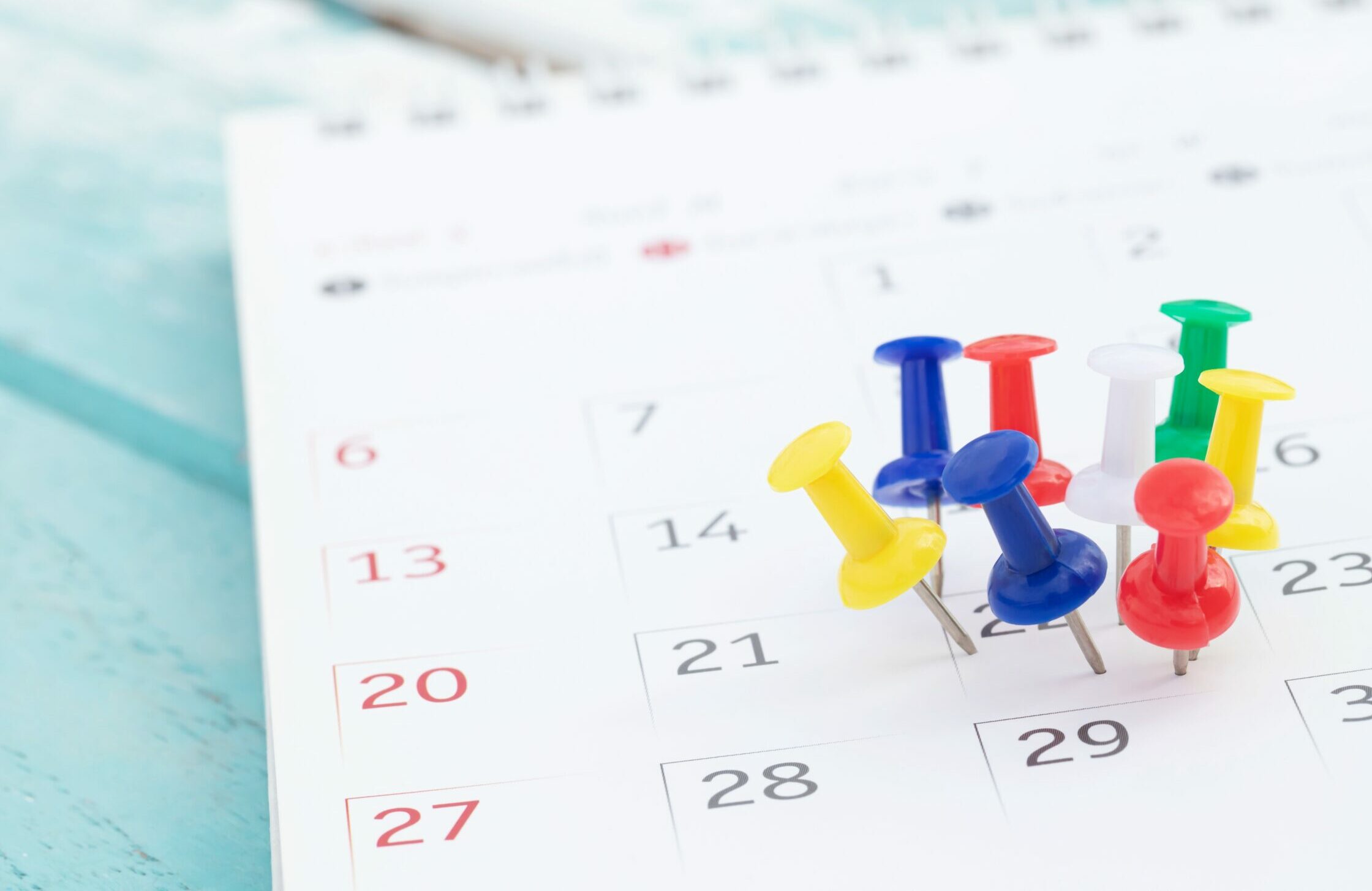 Symbolbild: In einem Kalender stecken viele bunte Reiszwecken am 22.ten des Monats.