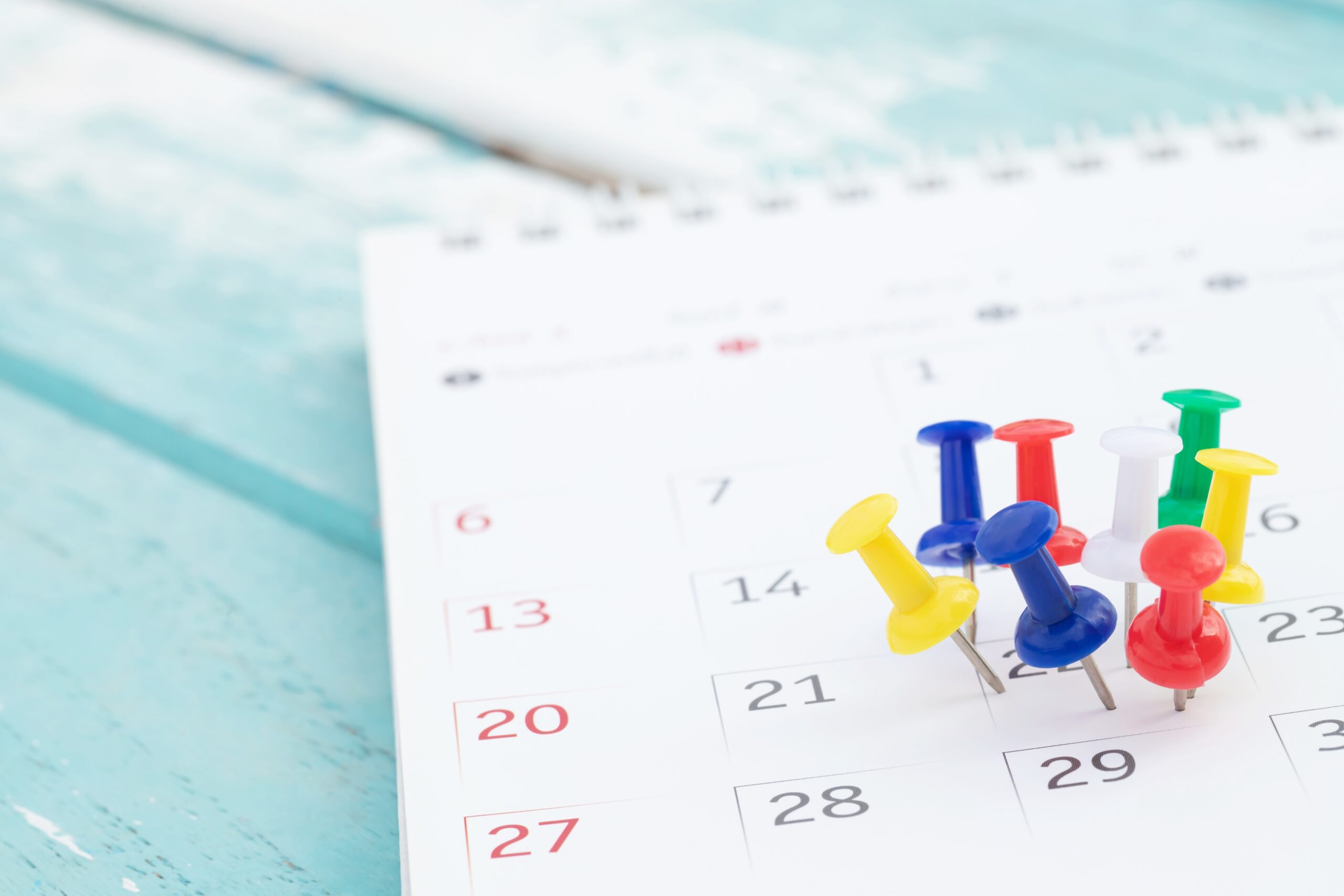 Symbolbild: In einem Kalender stecken viele bunte Reiszwecken am 22.ten des Monats.