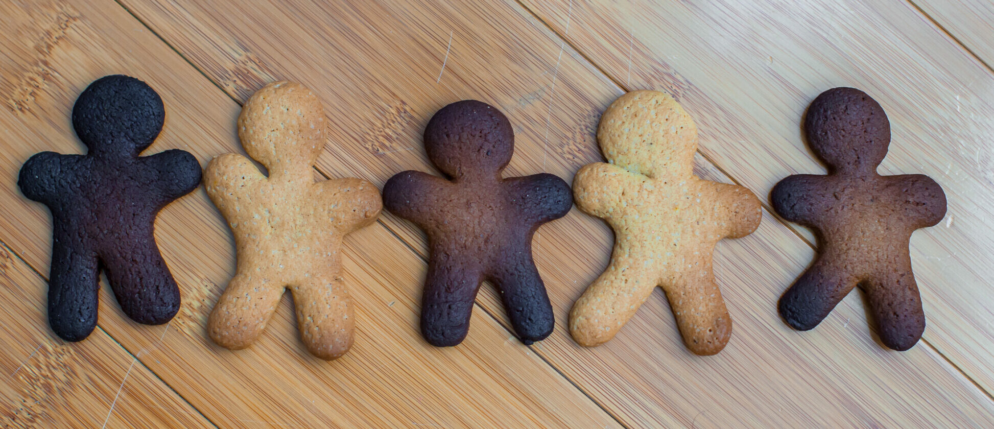 Symbolbild: mehrere Lebkuchenmänner liegen nebeneinander in verschiedenen bräunungsgraden. Einer ist verkohlt.