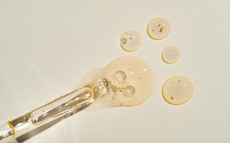 Symbolbild: Eine Pipette aus der ein gelbliches Gel tropft.