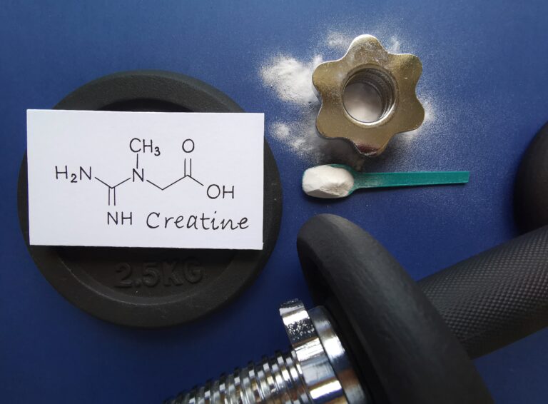Symbolbild: Die Stukturformel von Kreatin, eine Hantel und das Pulver liegen auf einem blauen Hintergrund.