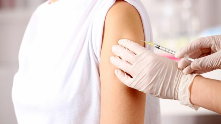 Symblbild impfen, Frau bekommt Spritze in den Oberarm
