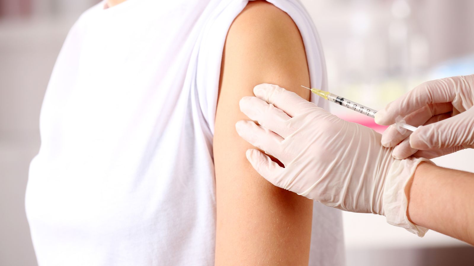 Symblbild impfen, Frau bekommt Spritze in den Oberarm