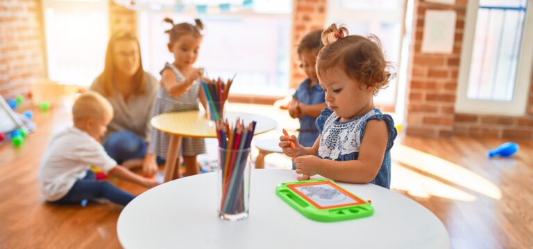 Kleinkinder spielen und malen gemeinsam im Kindergarten.