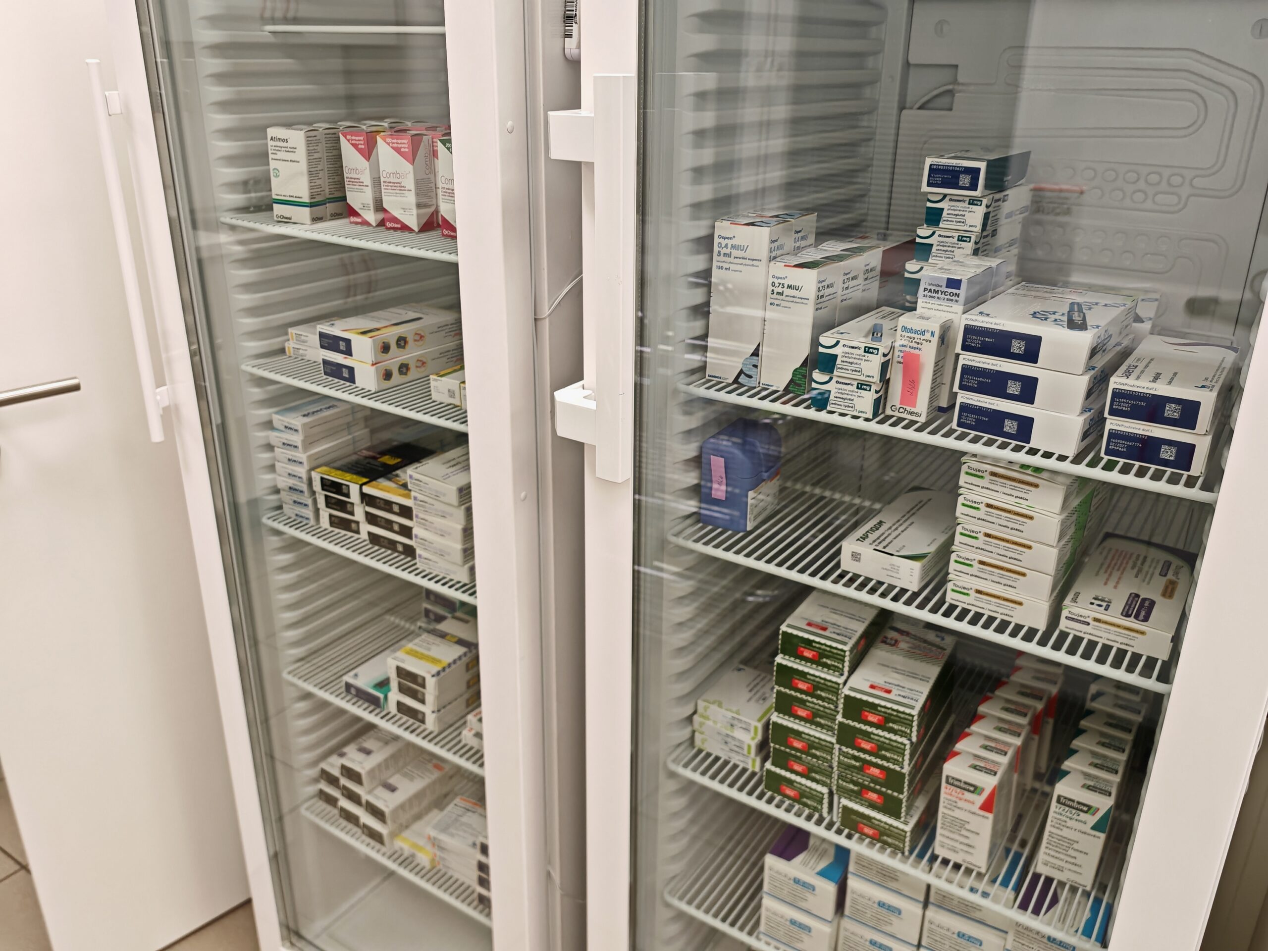 Symbolbild: Zwei Apothekenkühlschränke nebeneinander mit mehreren Fächern, in denen verschiedene Arzneimittelpackungen gelagert sind.