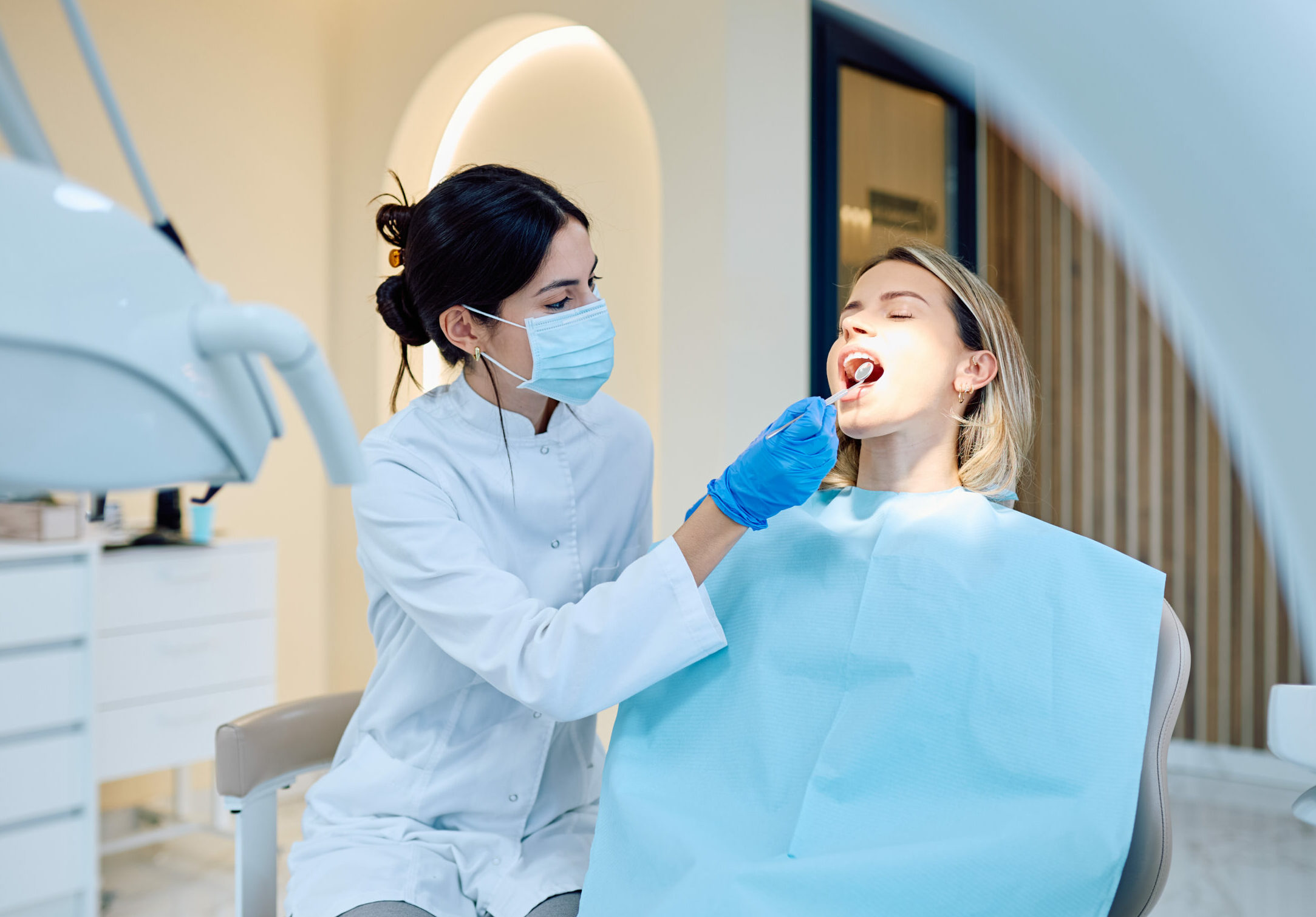 Eine jugendliche Frau wird bei einer Zahnärztin untersucht.