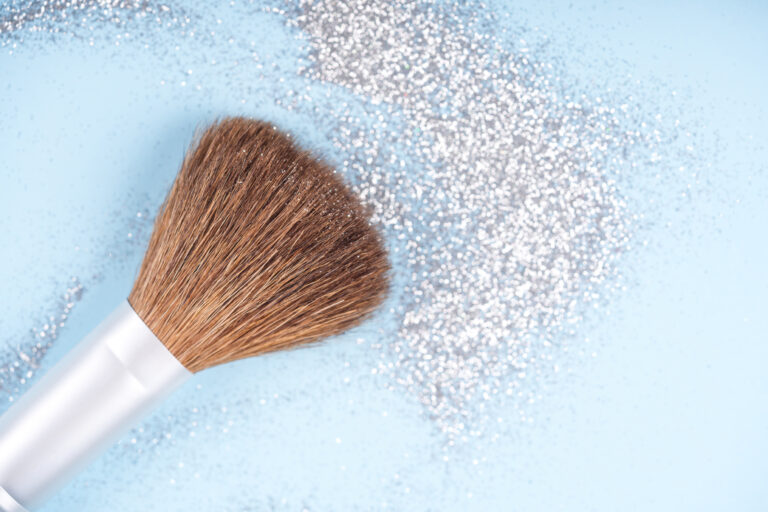 Symbolbild: Ein Make-up Pinsel mit silbernen Glitzer.