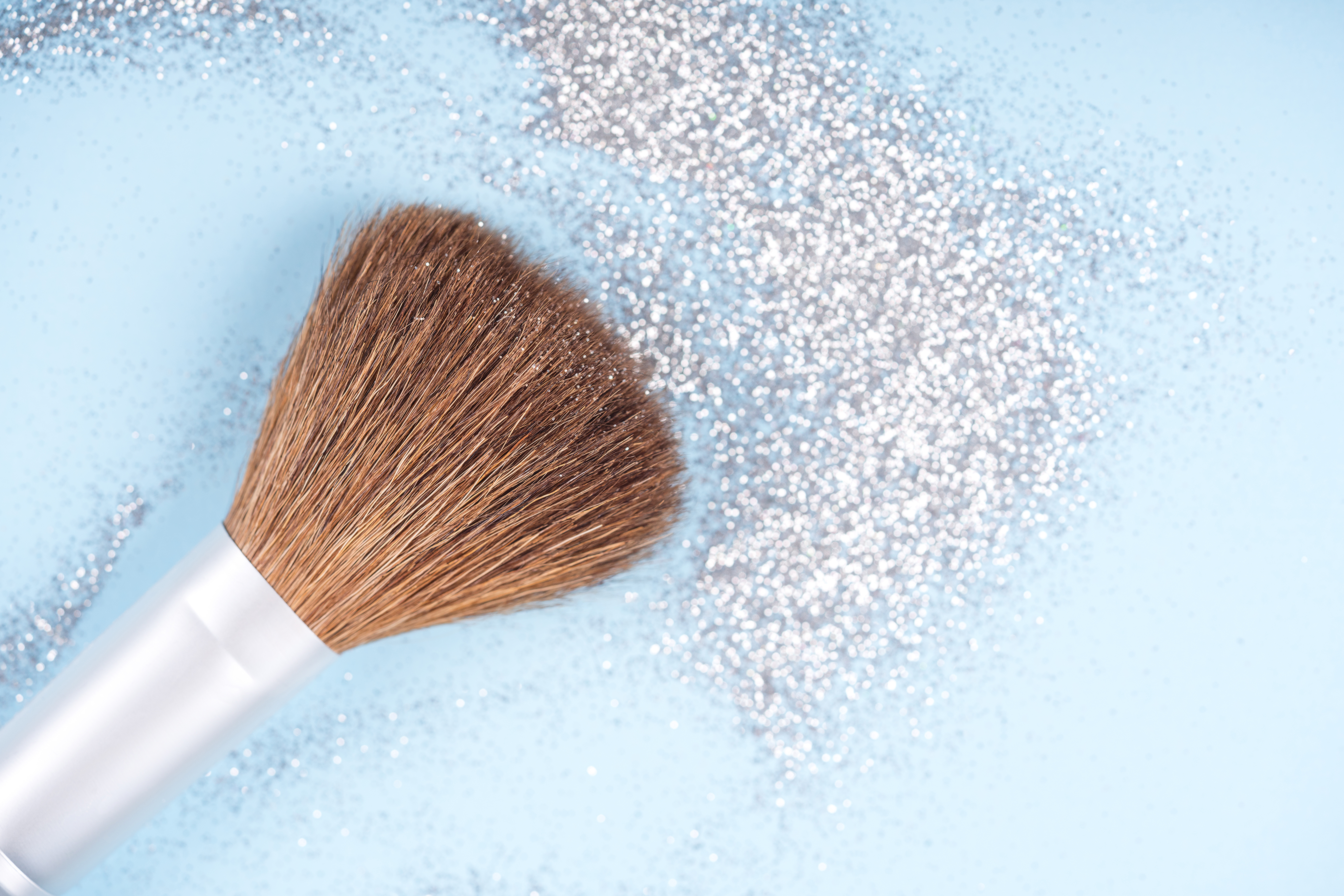 Symbolbild: Ein Make-up Pinsel mit silbernen Glitzer.