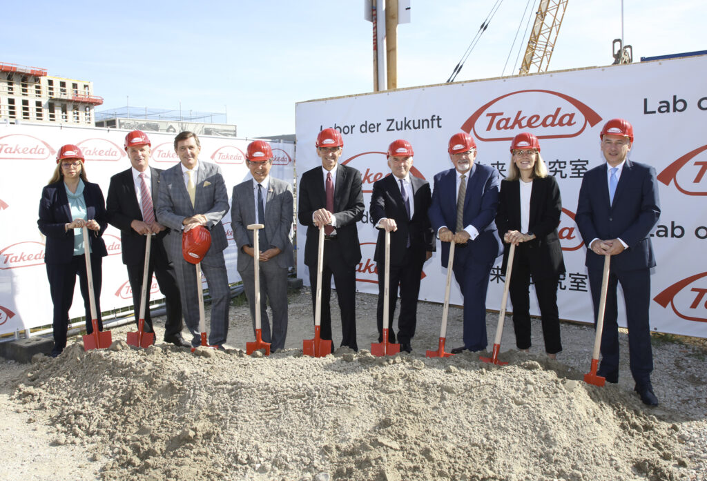 Spartenstich im September mit Mitarbeiter:innen von Takeda und Politikerinnen. Sie halten eine Schaufel und stehen im Sand.