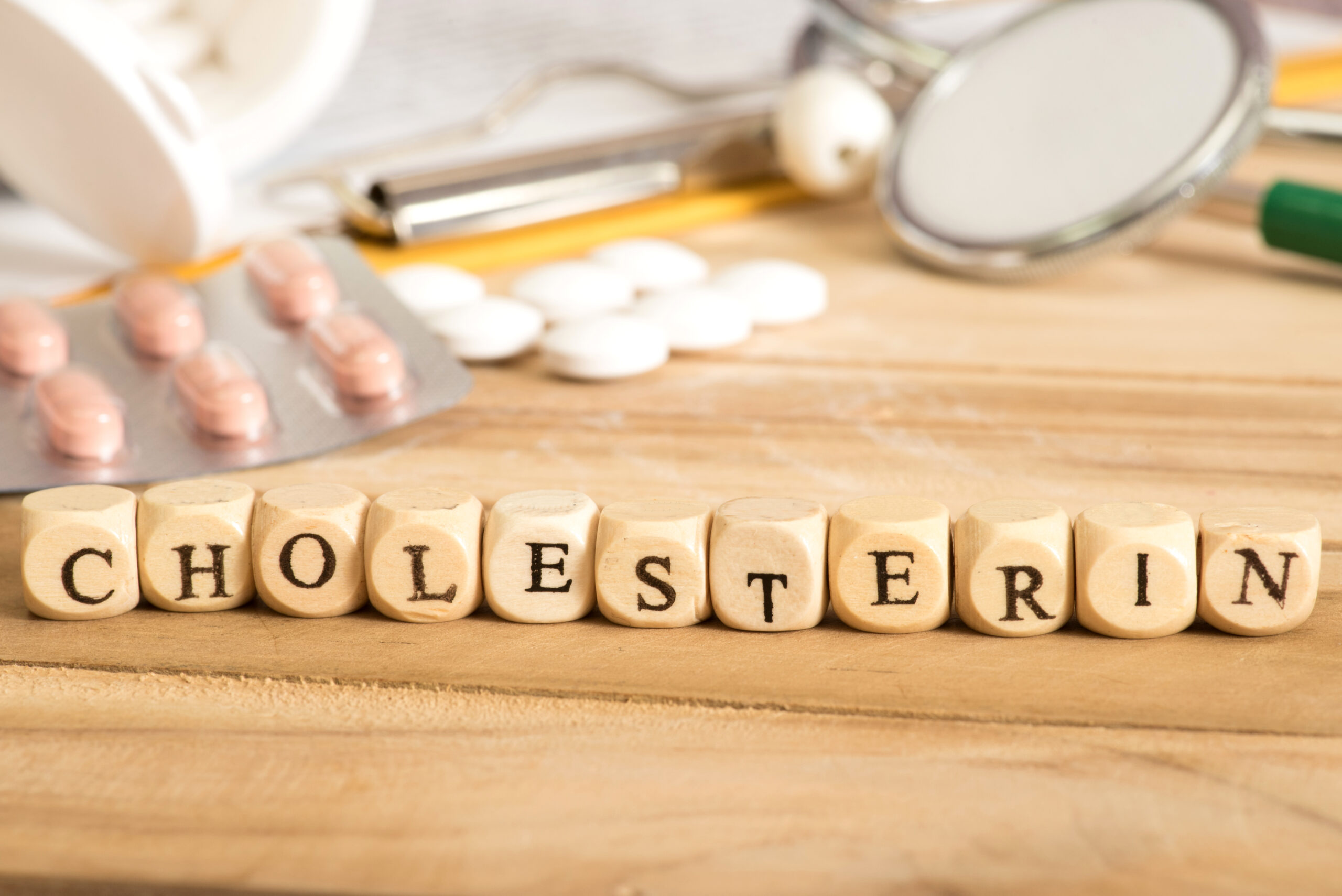Symbolbild: Holzsteine mit der Aufschrift "Cholesterin".