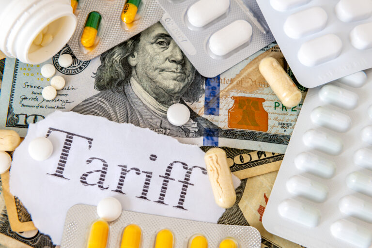 Symbolbild: Dollar liegt unter vielen Tabletten und Blistern und Kapseln. das Wort Tarif steht geschrieben.