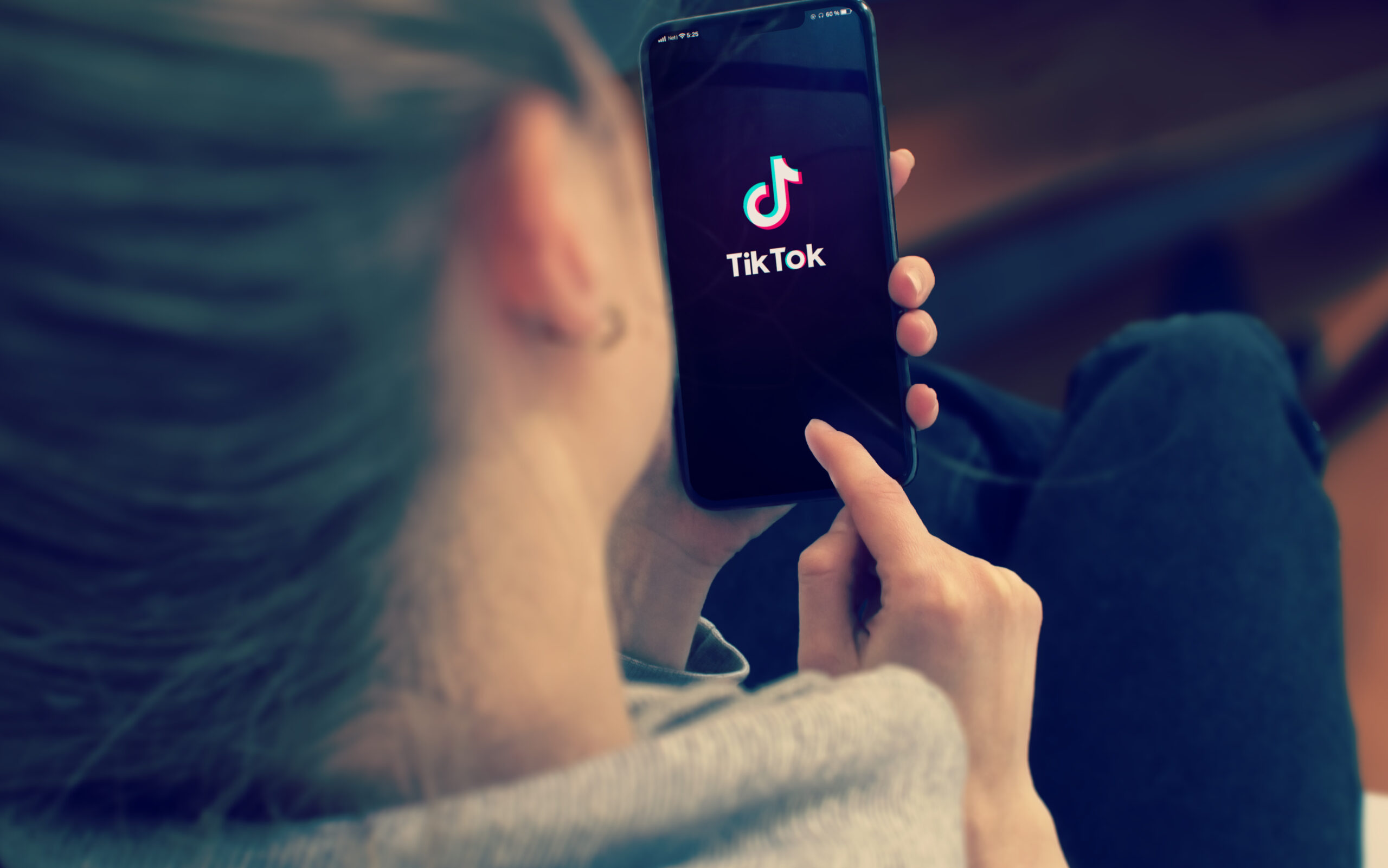 Symbolbild: Eine Frau die am Handy TikTok schaut.