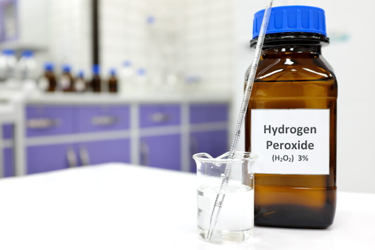 Symbolbild: Ein Gefäß beschriftet mit "Hydrogenperoxide 3 Prozent", daneben ein Becherglas mit einem Rührstab.