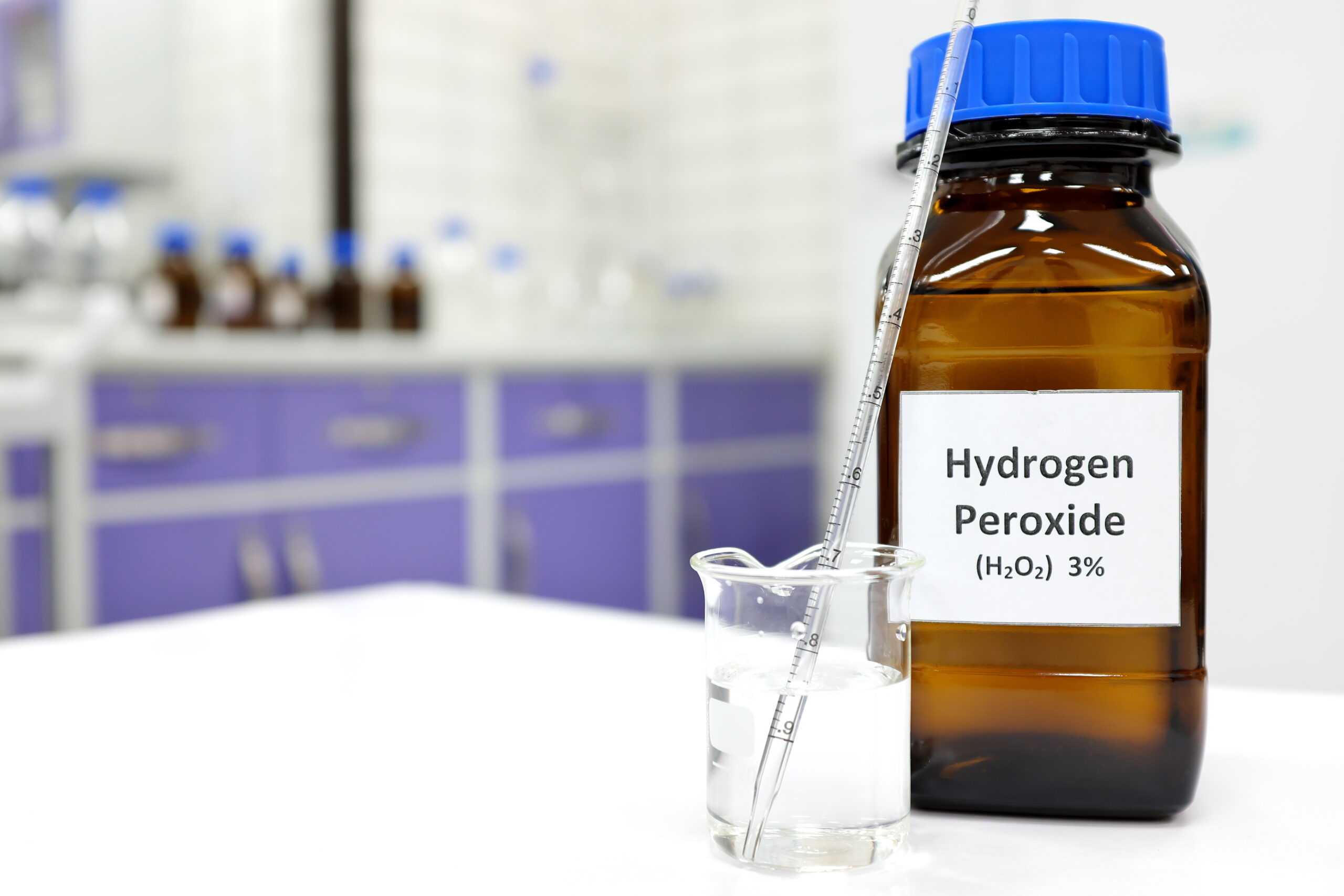 Symbolbild: Ein Gefäß beschriftet mit "Hydrogenperoxide 3 Prozent", daneben ein Becherglas mit einem Rührstab.