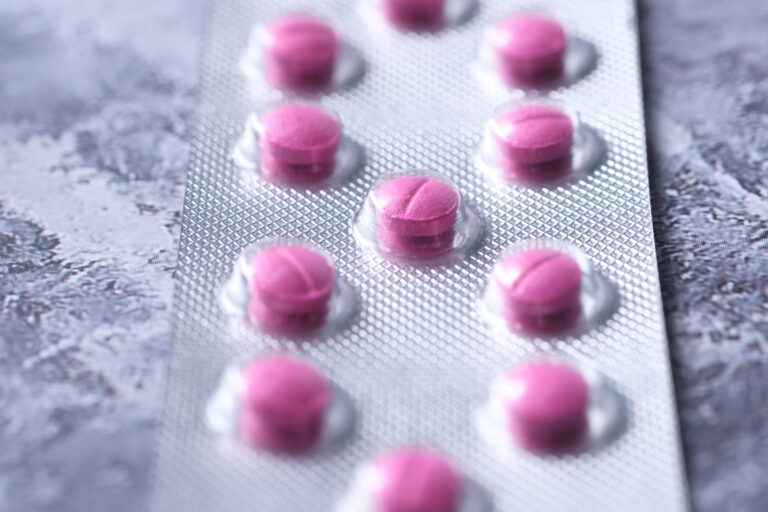 Symbolbild: Nahaufnahme von einem Tablettenblister gefüllt mit kleinen rosa Tabletten.
