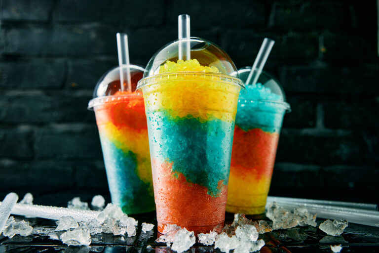 Symbolbild: Buten Slushys in Regenbogenfarben neben Eis