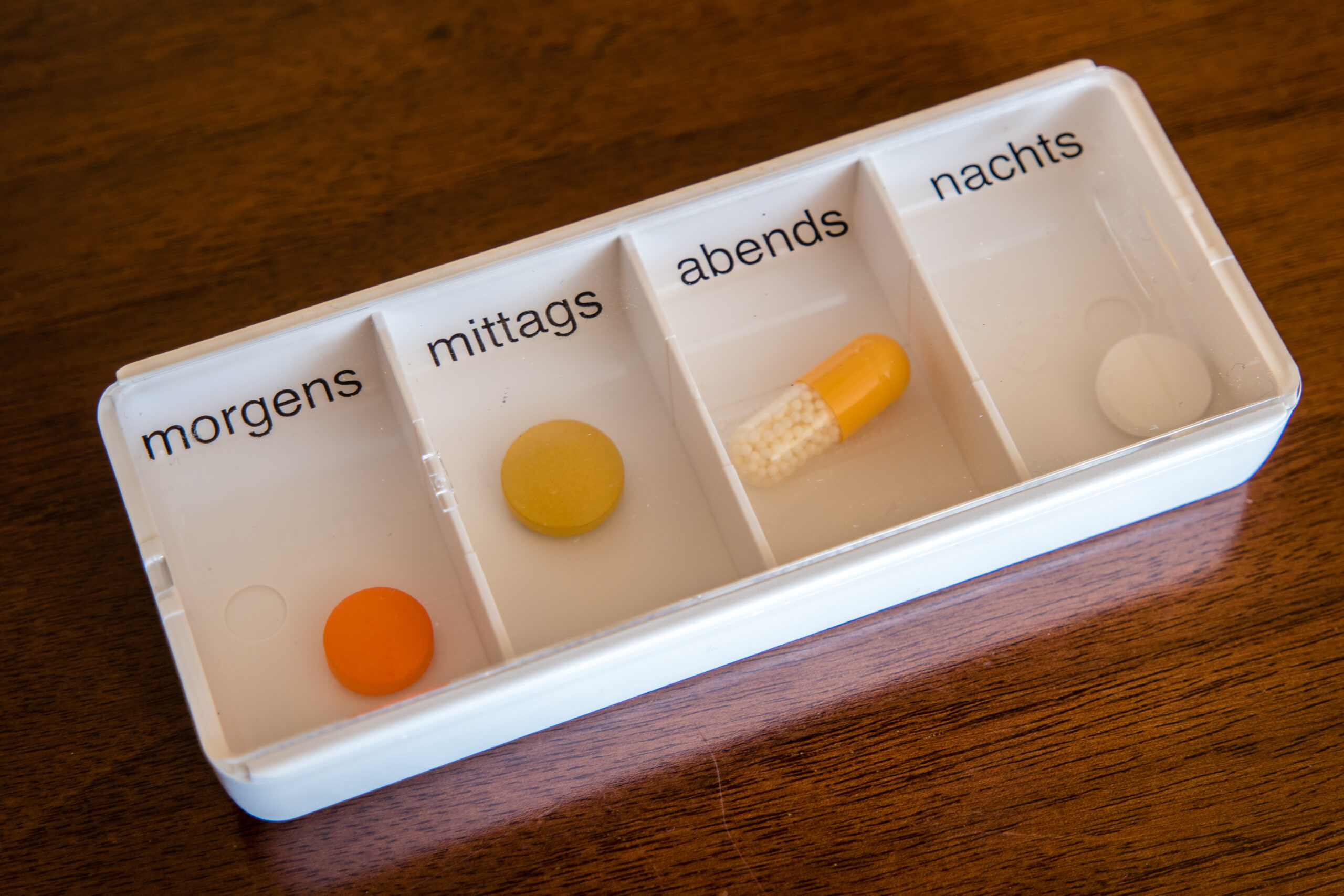 Symbolbild: Eine Tablettenbox mit morgens, mittags, abends, nachts. Darin sind Kapseln und Tabletten.