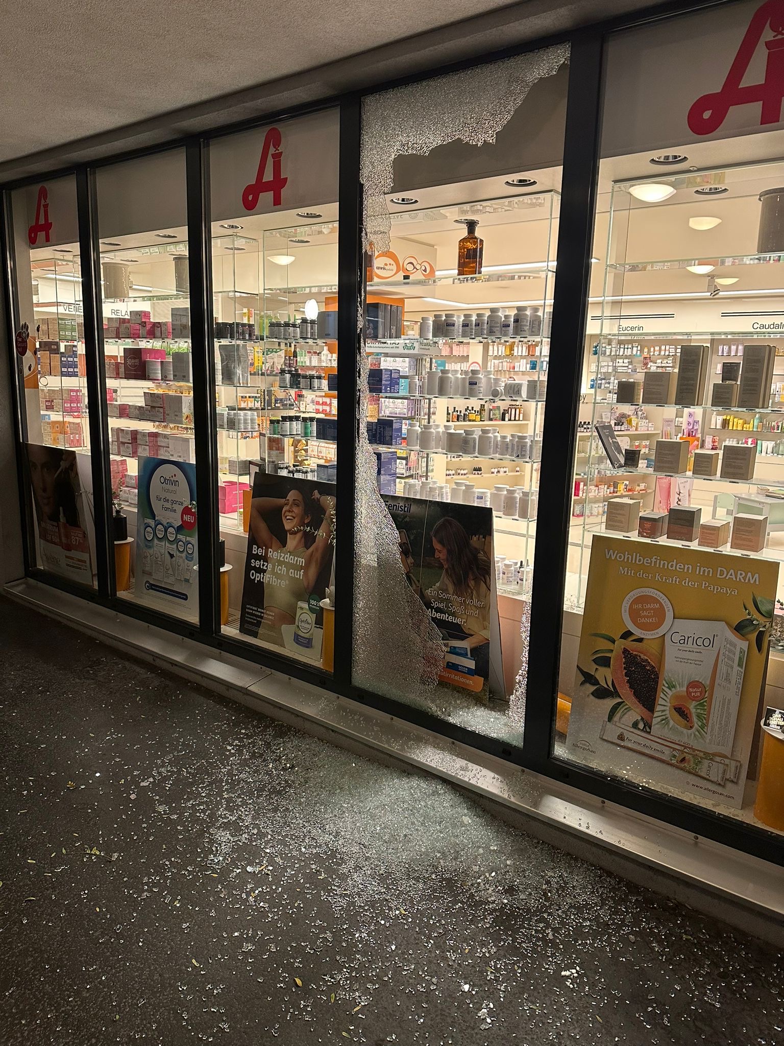 Das eingeschlagene Schaufenster der Apotheke.